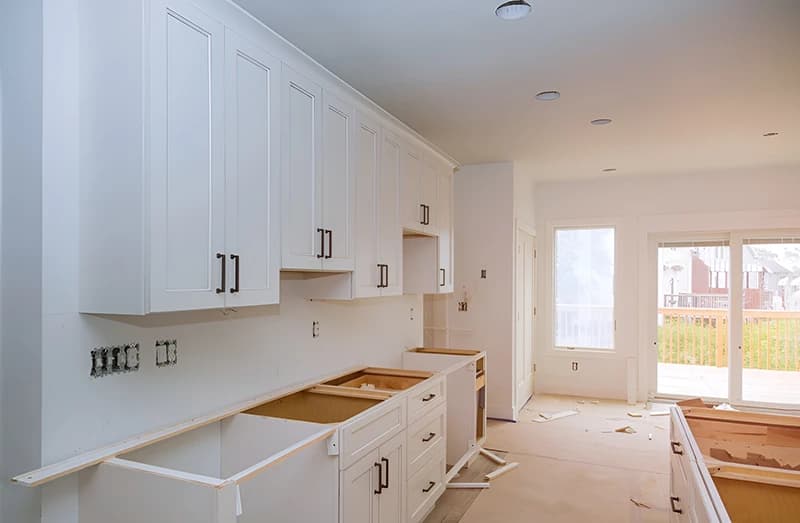 A white shaker kitchen with the base units in place and no worktop fitted